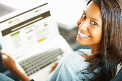 Rear-view of woman working on laptop indoors